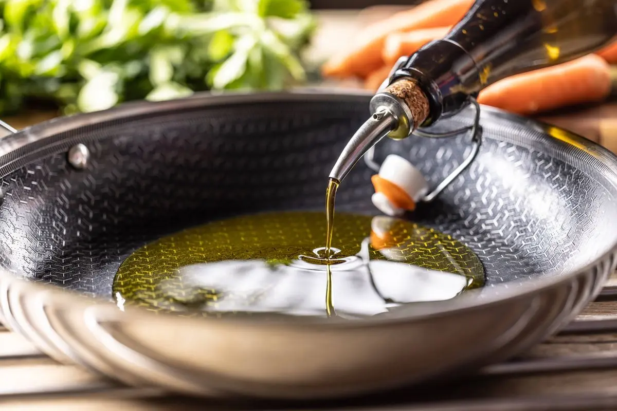 روغن زیتون داخل کاسه سرخ کردن ریخته می‌شود