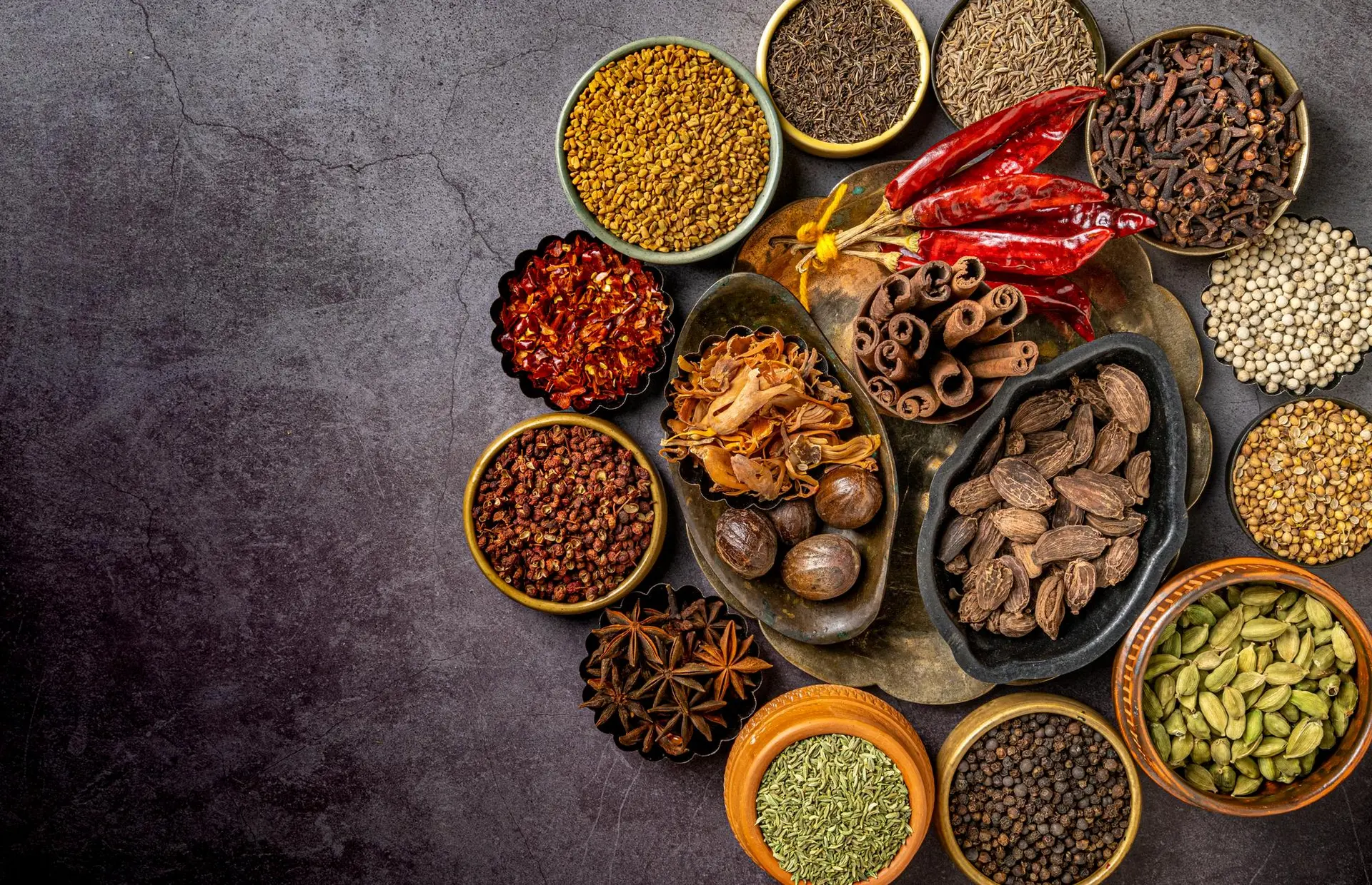 چندین نوع ادویه خشک در ظرف شیشهای شفاف