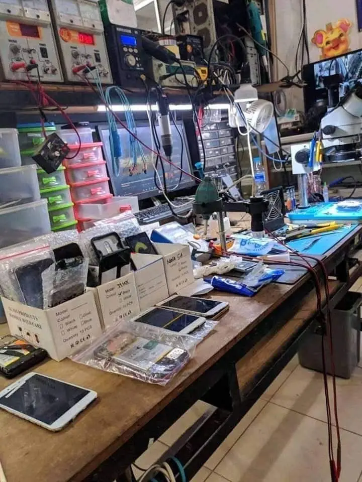 ابزارهای سازماندهی شده روی یک میز تعمیرات موبایل با نورپردازی مناسب