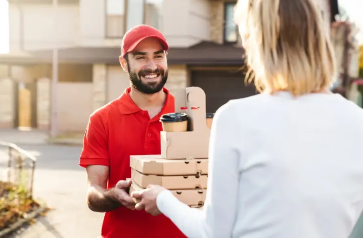 یک فرد در حال بررسی اپلیکیشن سرویس غذاخوری بر روی تلفن همراه